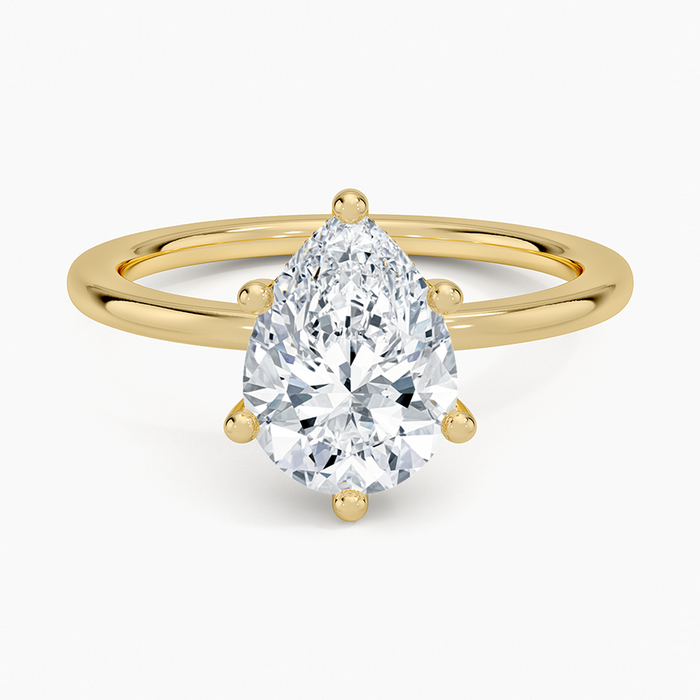 Pear cut moissanite in six claws on a plain slim round band in yellow gold, top view