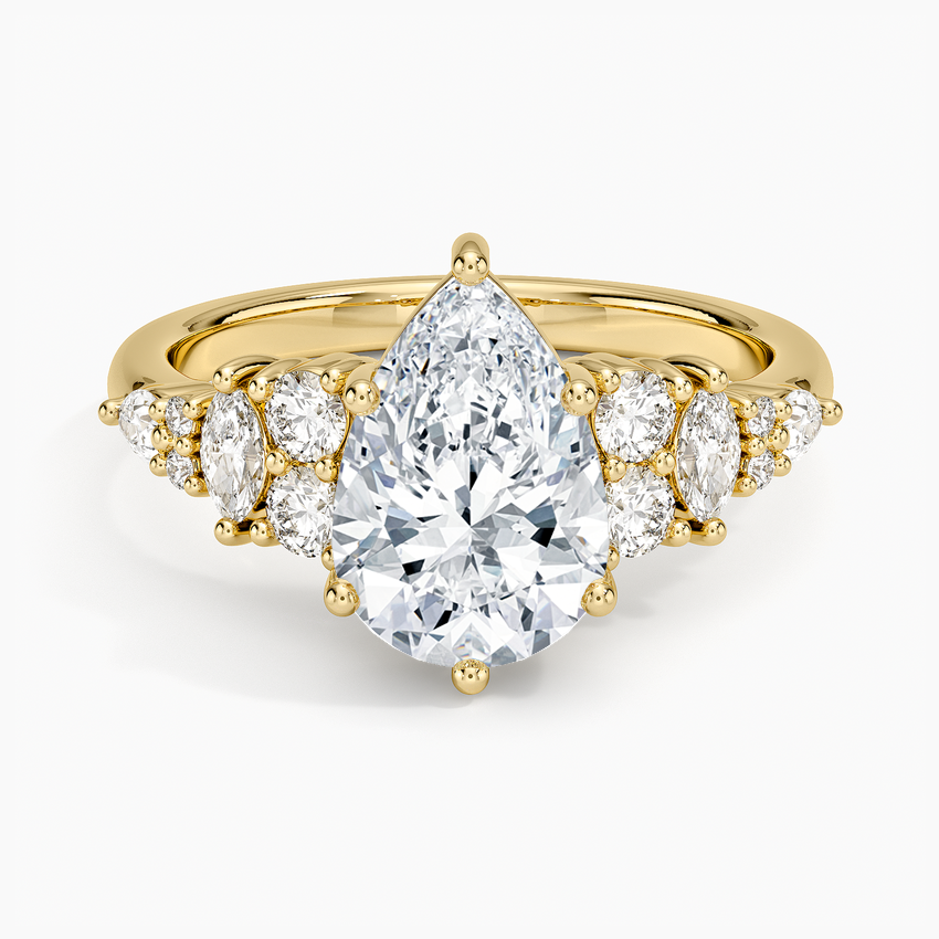 Pear cut moissanite with a marquise and round cluster on each shoulder in yellow gold, top view