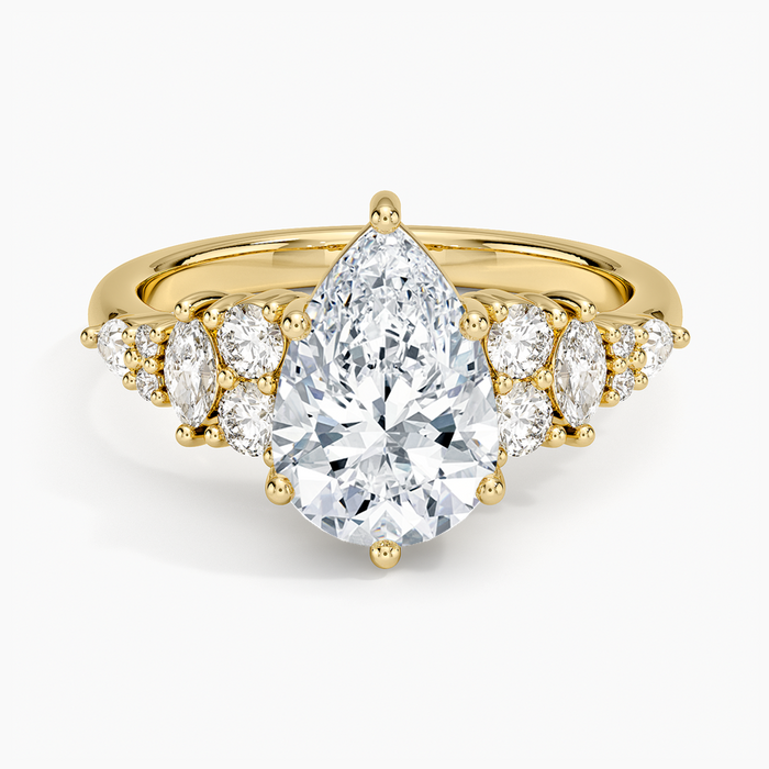 Pear cut moissanite with a marquise and round cluster on each shoulder in yellow gold, top view