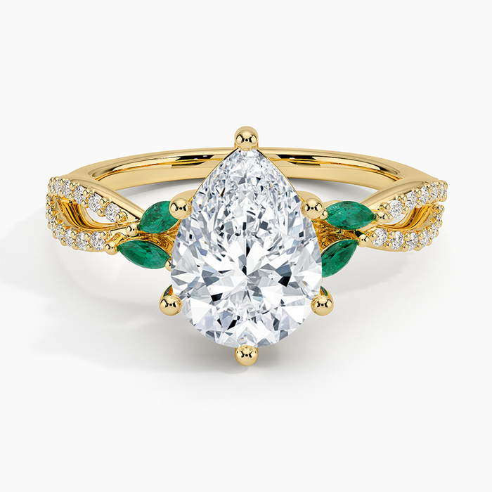 Pear cut moissanite twisted vine engagement ring with green marquise emerald leaves in yellow gold, top view