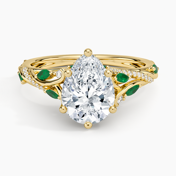 Pear cut moissanite with marquise green emerald leaves on pave vine branches in yellow gold, top view