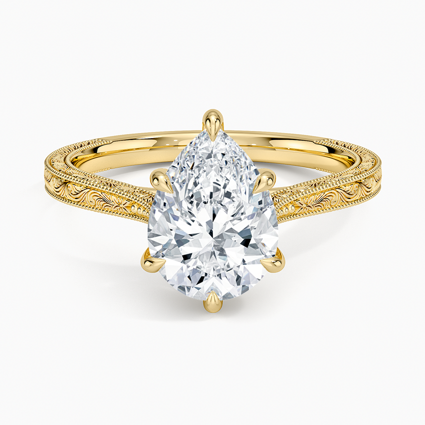 Pear cut moissanite hand engraved knife edge engagement ring in yellow gold, top view
