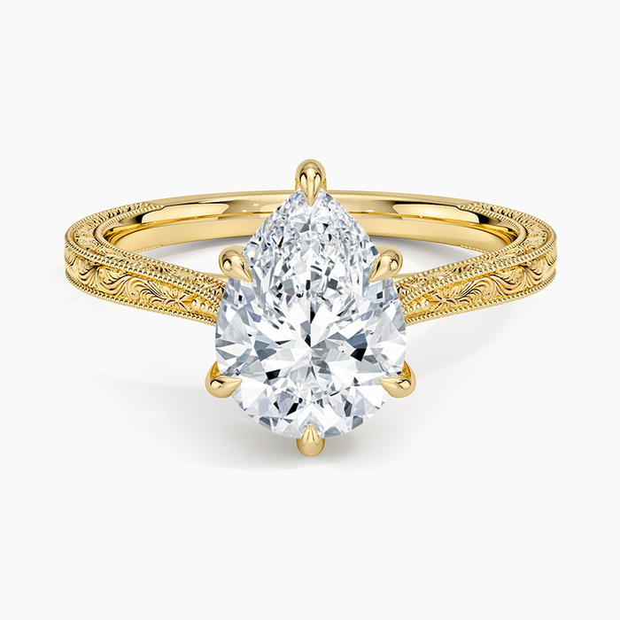 Pear cut moissanite hand engraved knife edge engagement ring in yellow gold, top view