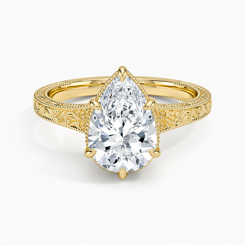 Pear cut moissanite above a hand engraved baroque scroll band with milgrain in yellow gold, top view