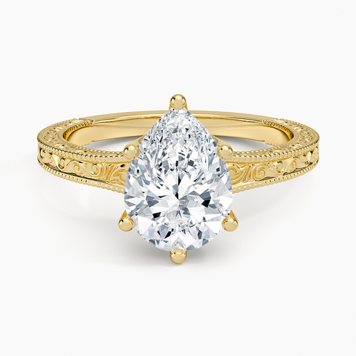 Pear cut moissanite on a flat faced band engraved with a scroll and milgrain edges in yellow gold, top view