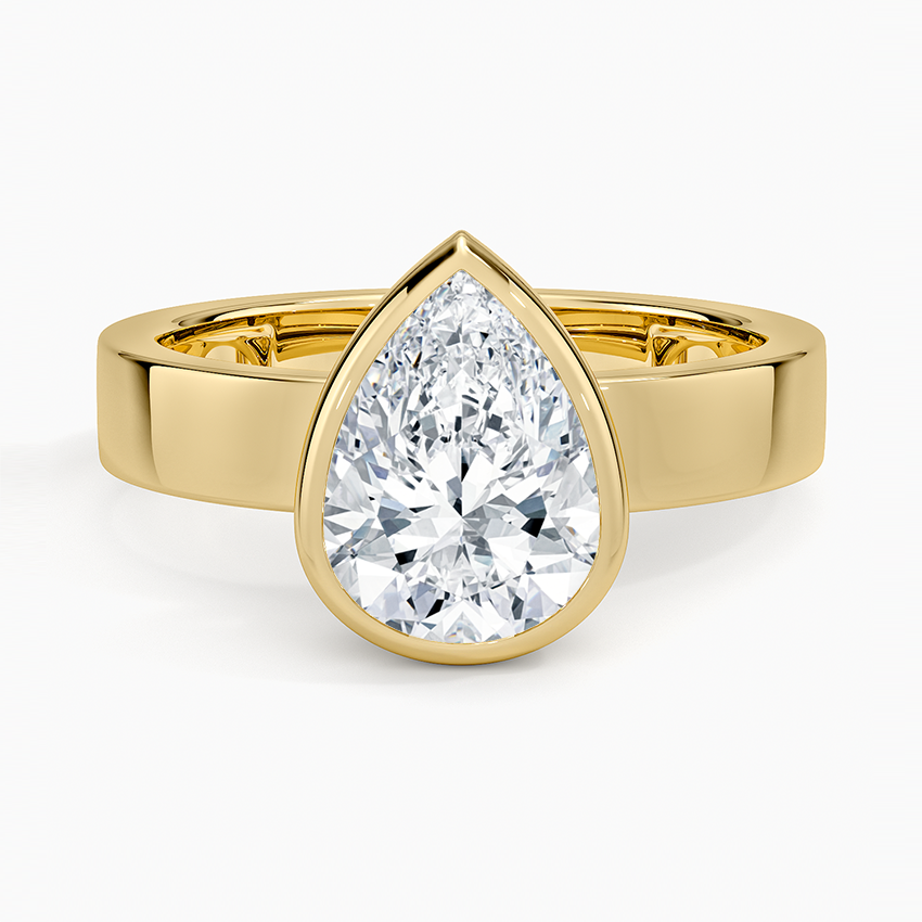 Bezel set pear cut moissanite on a wide flat square edged band in yellow gold, top view