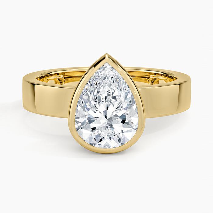 Bezel set pear cut moissanite on a wide flat square edged band in yellow gold, top view