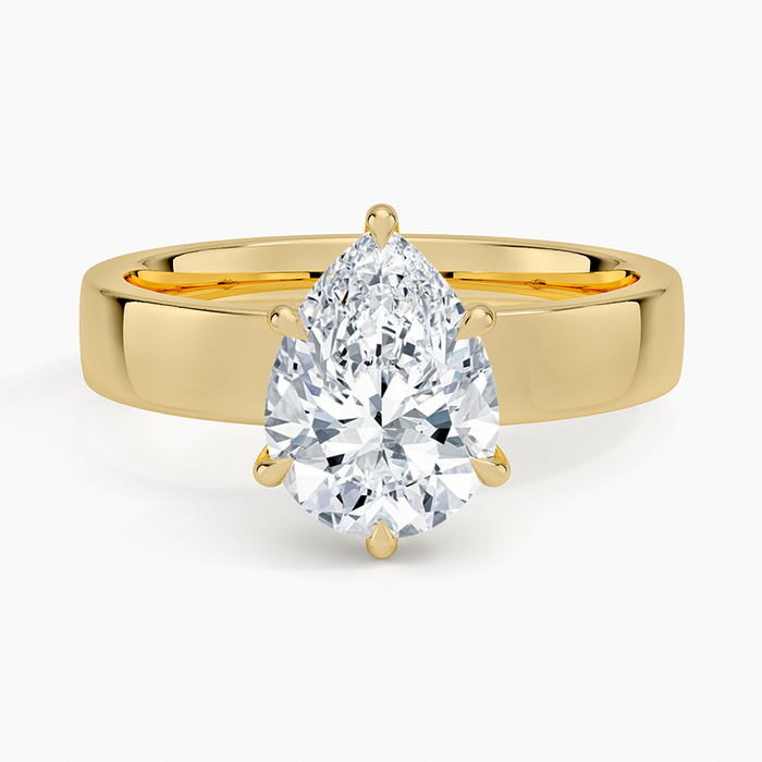 Pear cut moissanite in six claws on a wide flat square edged band in yellow gold, top view