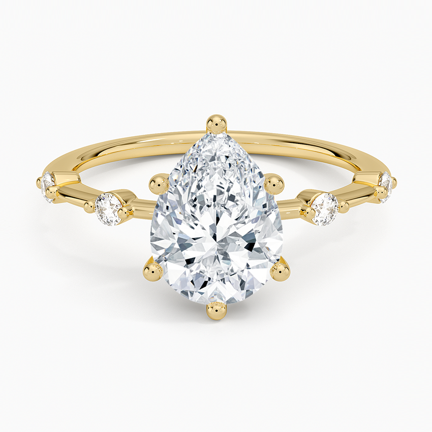 Pear cut moissanite graduated spaced accent engagement ring in yellow gold, top view