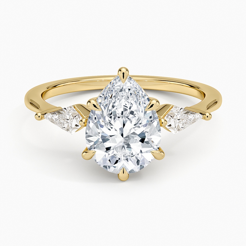 Pear cut moissanite three stone ring with kite cut side stones in yellow gold, top view