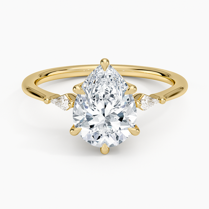 Pear cut moissanite three stone engagement ring with matching pear side stones in yellow gold, top view