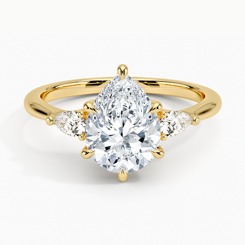 Pear cut moissanite three stone engagement ring in yellow gold, top view