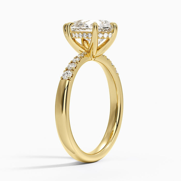 Side view showing the hidden halo under the pear and shared prongs between the accents