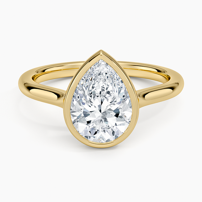Pear cut moissanite in a fine bezel on a slim band in yellow gold, top view