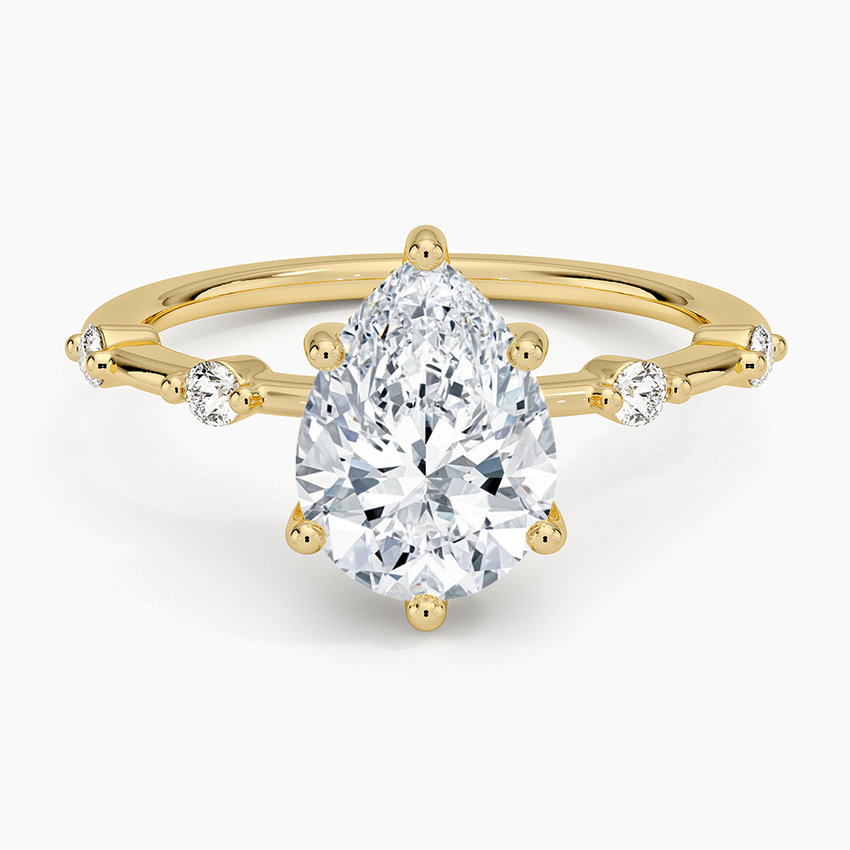 Pear cut moissanite spaced accent constellation engagement ring in yellow gold, top view