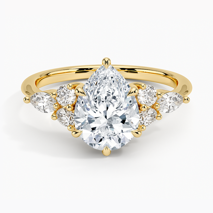Pear cut moissanite with mirrored marquise and round accents on each shoulder in yellow gold, top view