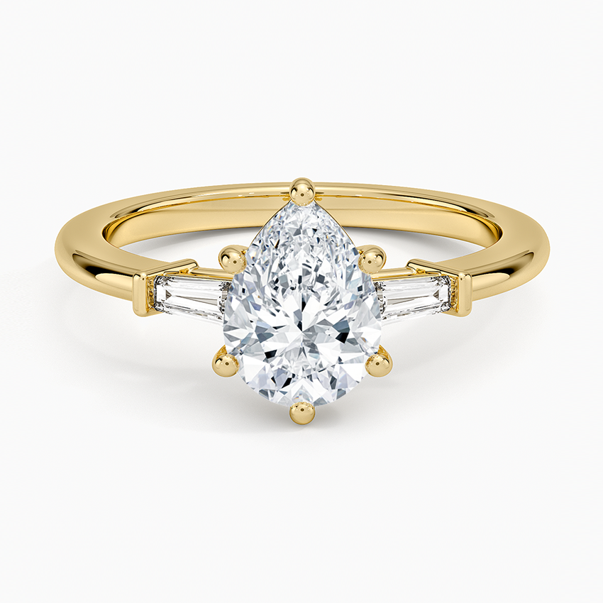 Pear cut moissanite tapered baguette three stone engagement ring in yellow gold, top view