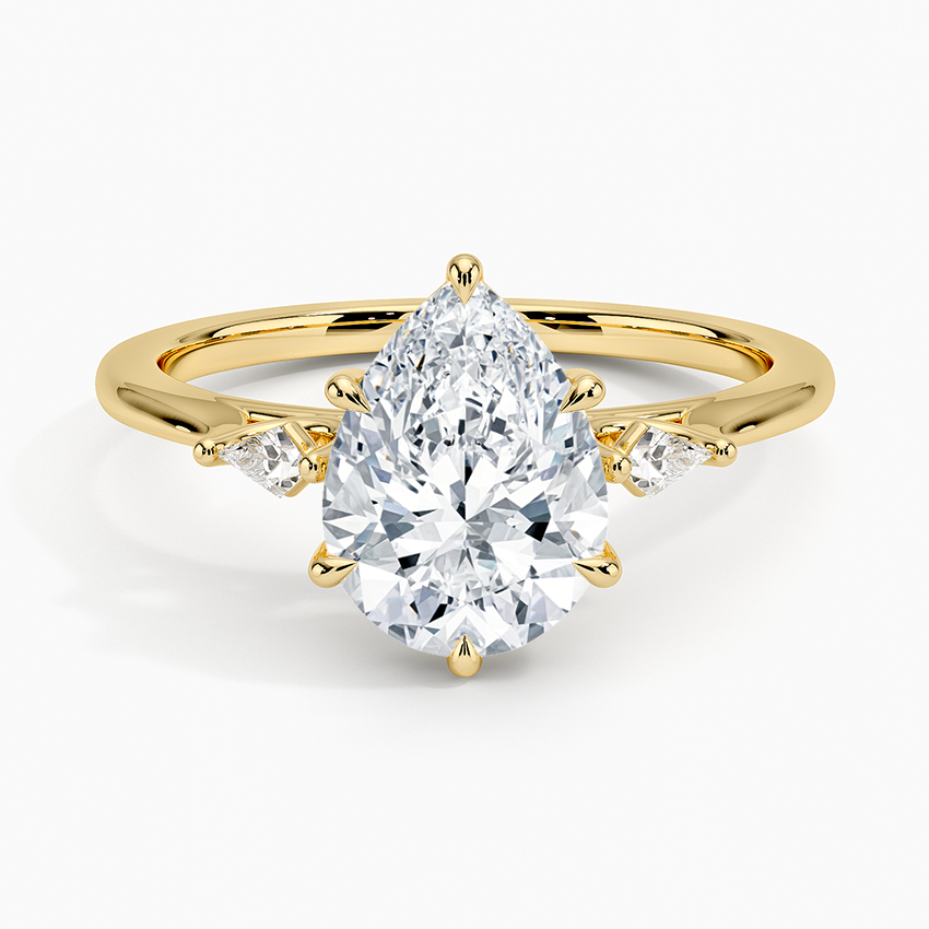 Pear cut moissanite petite kite three stone engagement ring in yellow gold, top view
