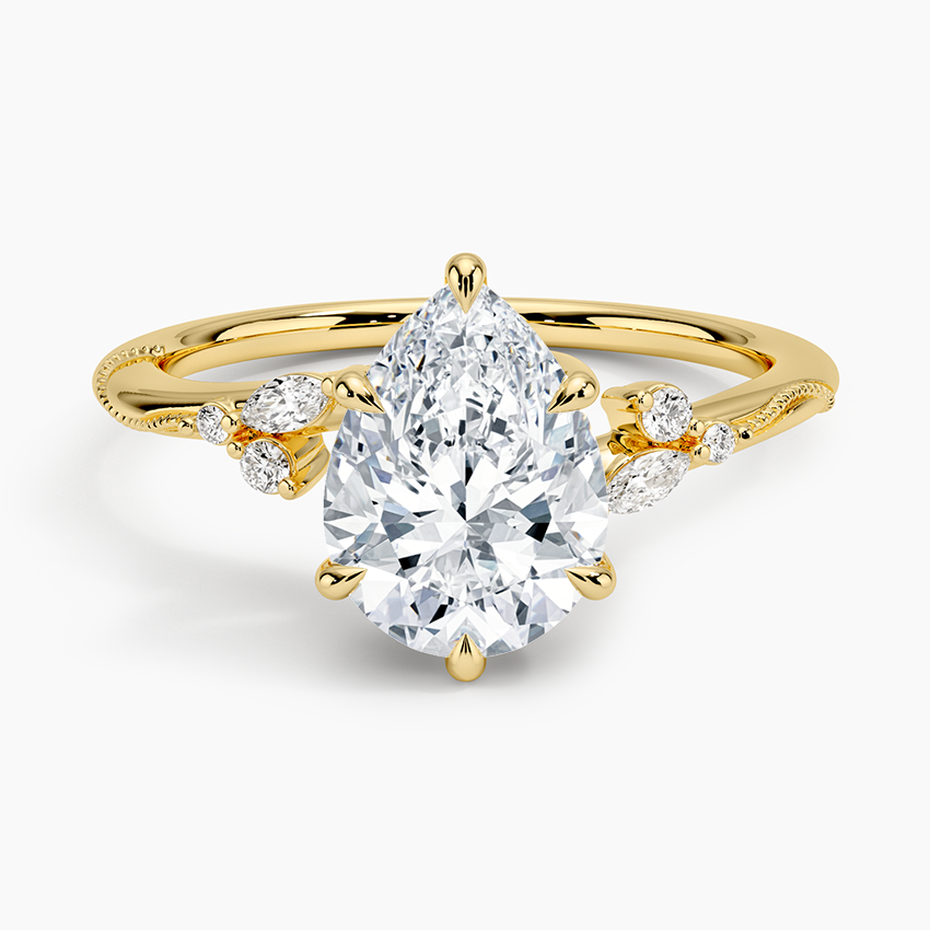 Pear cut moissanite on a twisting milgrain vine band with leaf accents in yellow gold, top view