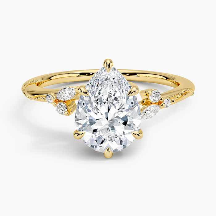 Pear cut moissanite on a twisting milgrain vine band with leaf accents in yellow gold, top view