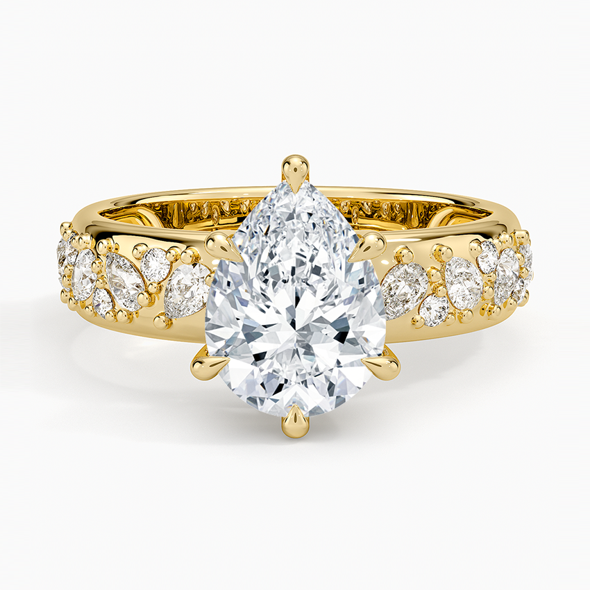Pear cut moissanite on a wide domed band packed with pear and round accents in yellow gold, top view