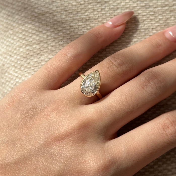 Pear cut moissanite bezel solitaire engagement ring with flat band in rose gold