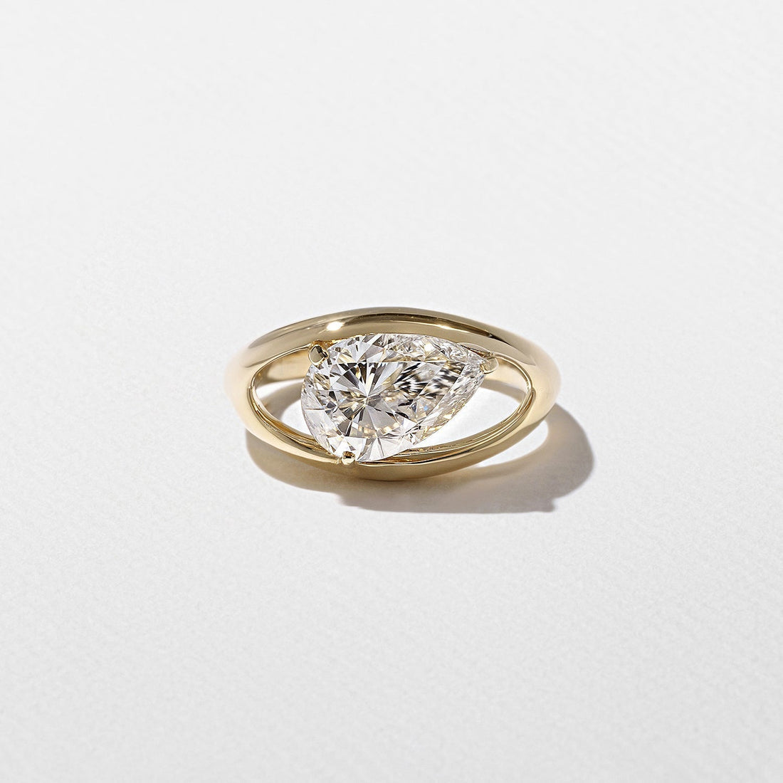 East west pear cut moissanite floating split shank engagement ring in yellow gold