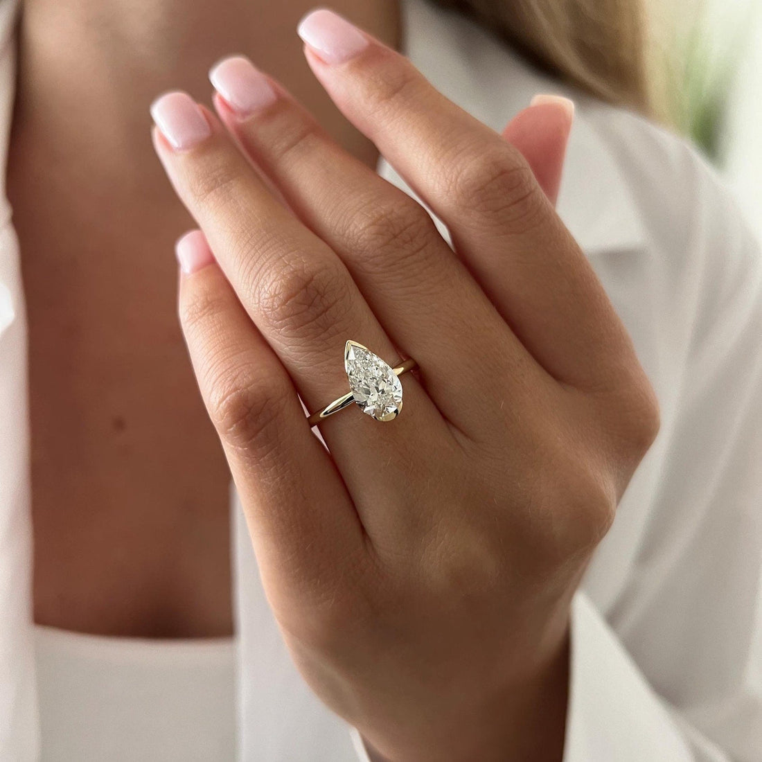Pear cut moissanite half bezel solitaire engagement ring in yellow gold