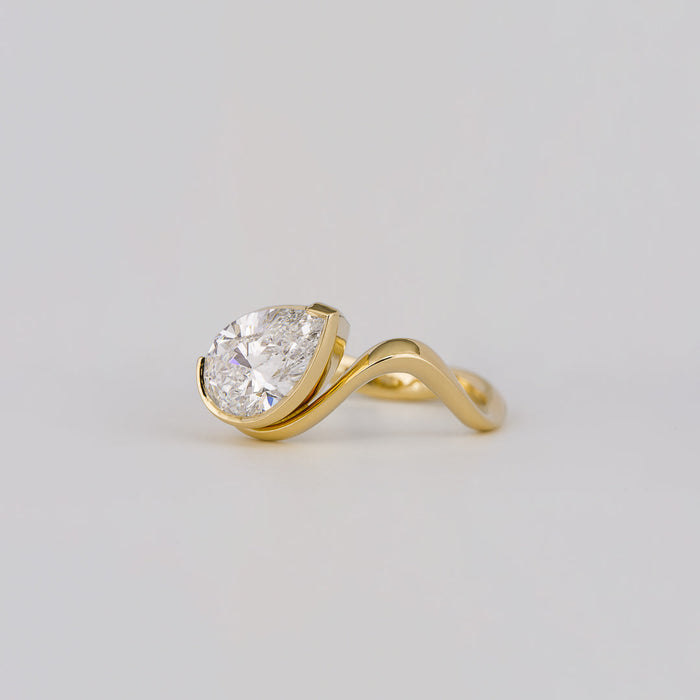 East west pear cut moissanite half bezel engagement ring on a curved yellow gold band, view 2