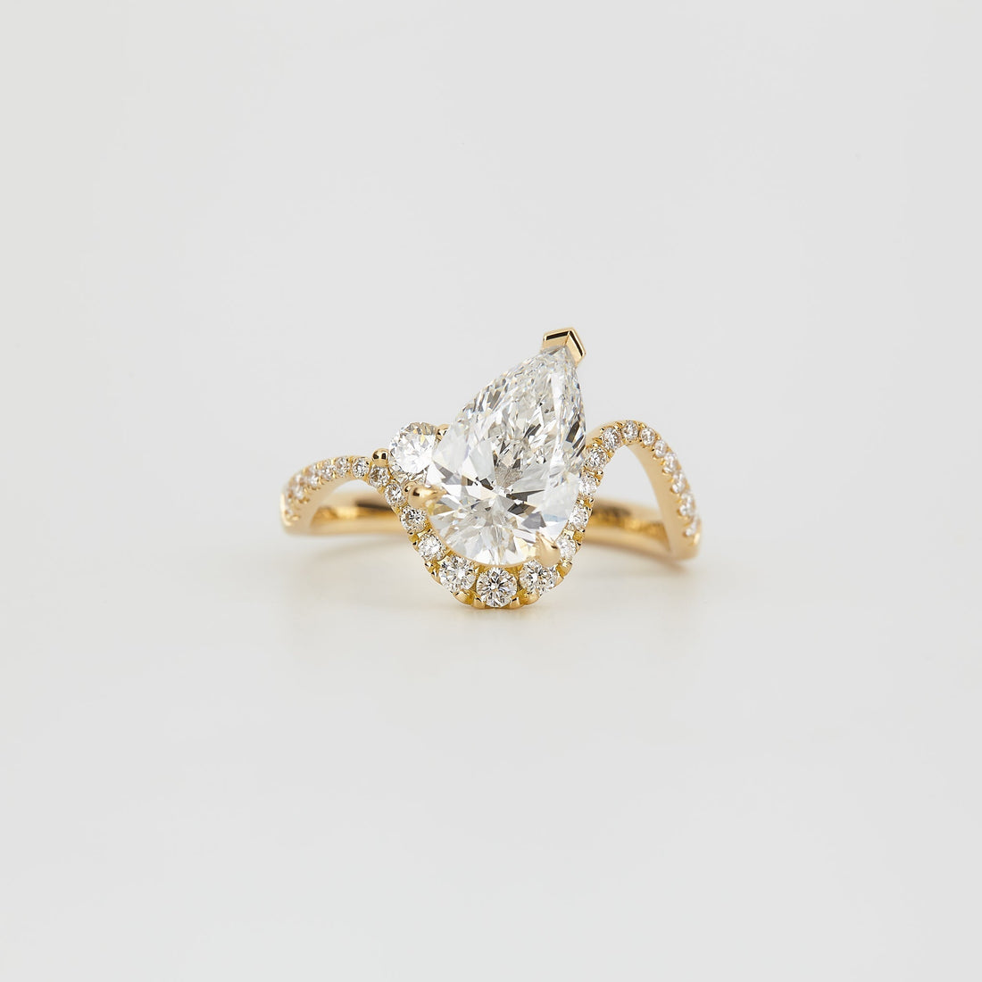 Pear cut moissanite half halo chevron pave engagement ring in yellow gold