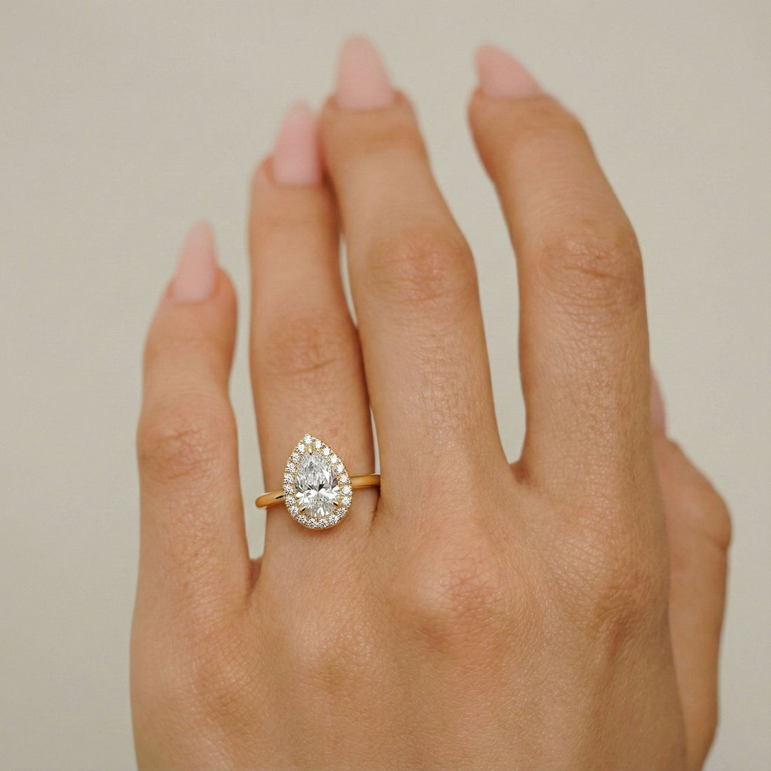 Pear cut moissanite halo engagement ring in yellow gold