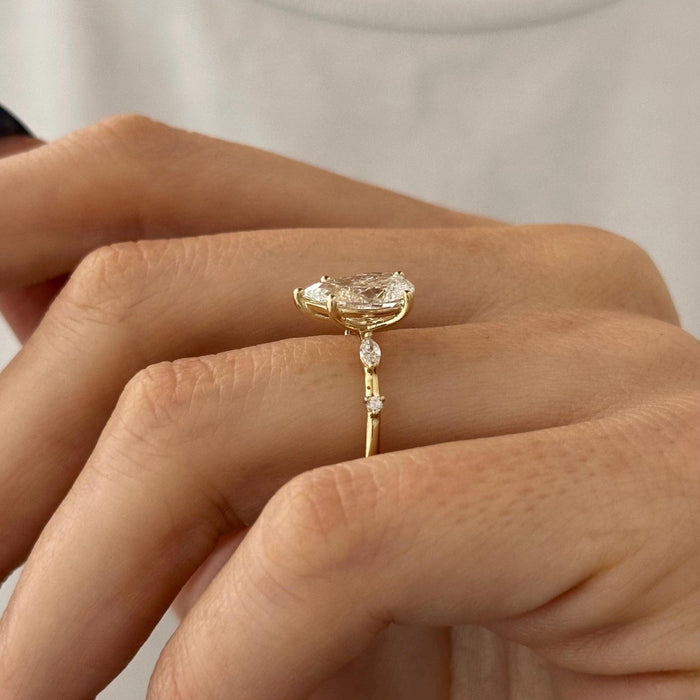 Pear cut moissanite engagement ring with mixed cut accent shoulders in yellow gold, view 2