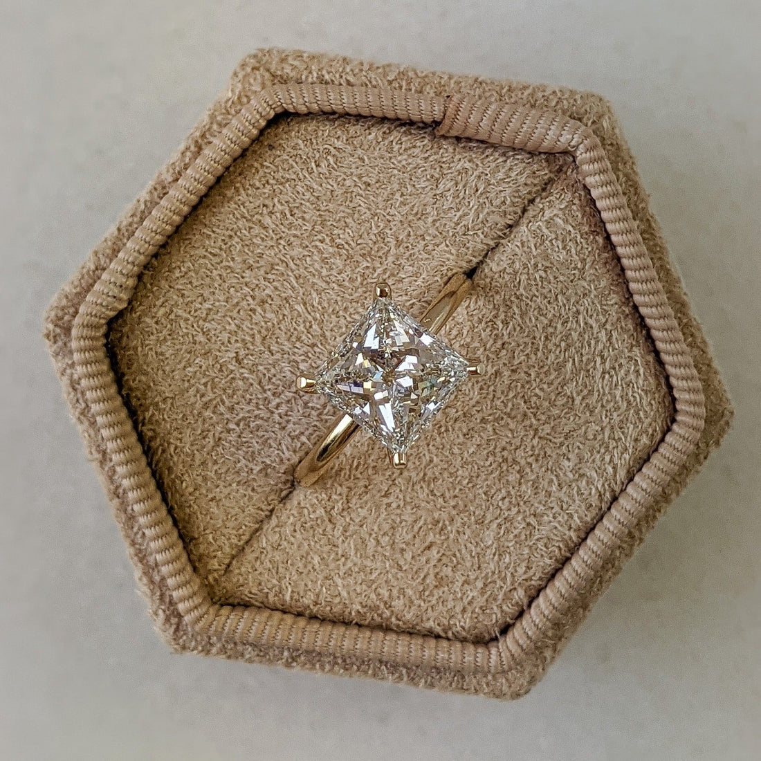 Princess cut moissanite set on point as a solitaire on a fine yellow gold band