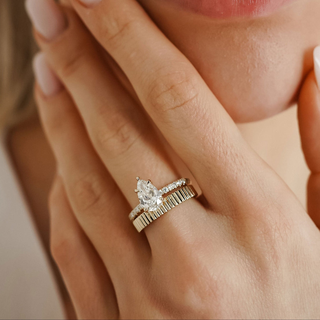 Pear cut moissanite pave band engagement ring in yellow gold