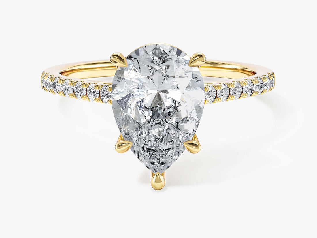 Pear shaped moissanite engagement ring with half pave band in yellow gold, front view