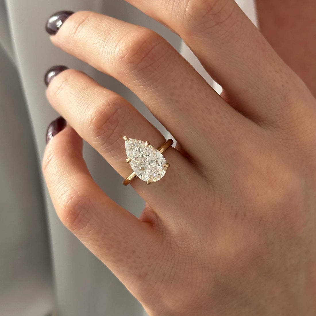 Pear cut moissanite six claw solitaire engagement ring in yellow gold