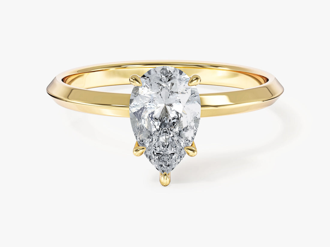 Dainty teardrop pear moissanite solitaire on a slim knife edge band in 14K yellow gold, front view