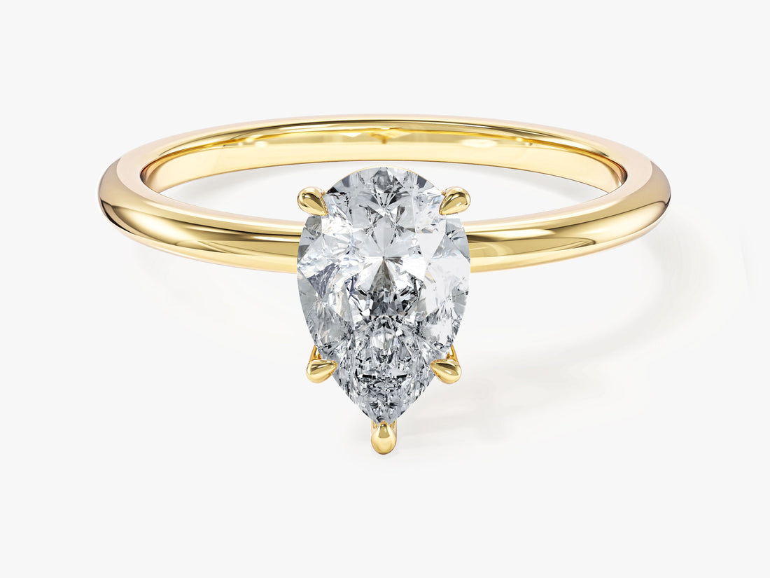 Minimalist pear moissanite solitaire engagement ring on a slim band in yellow gold, front view