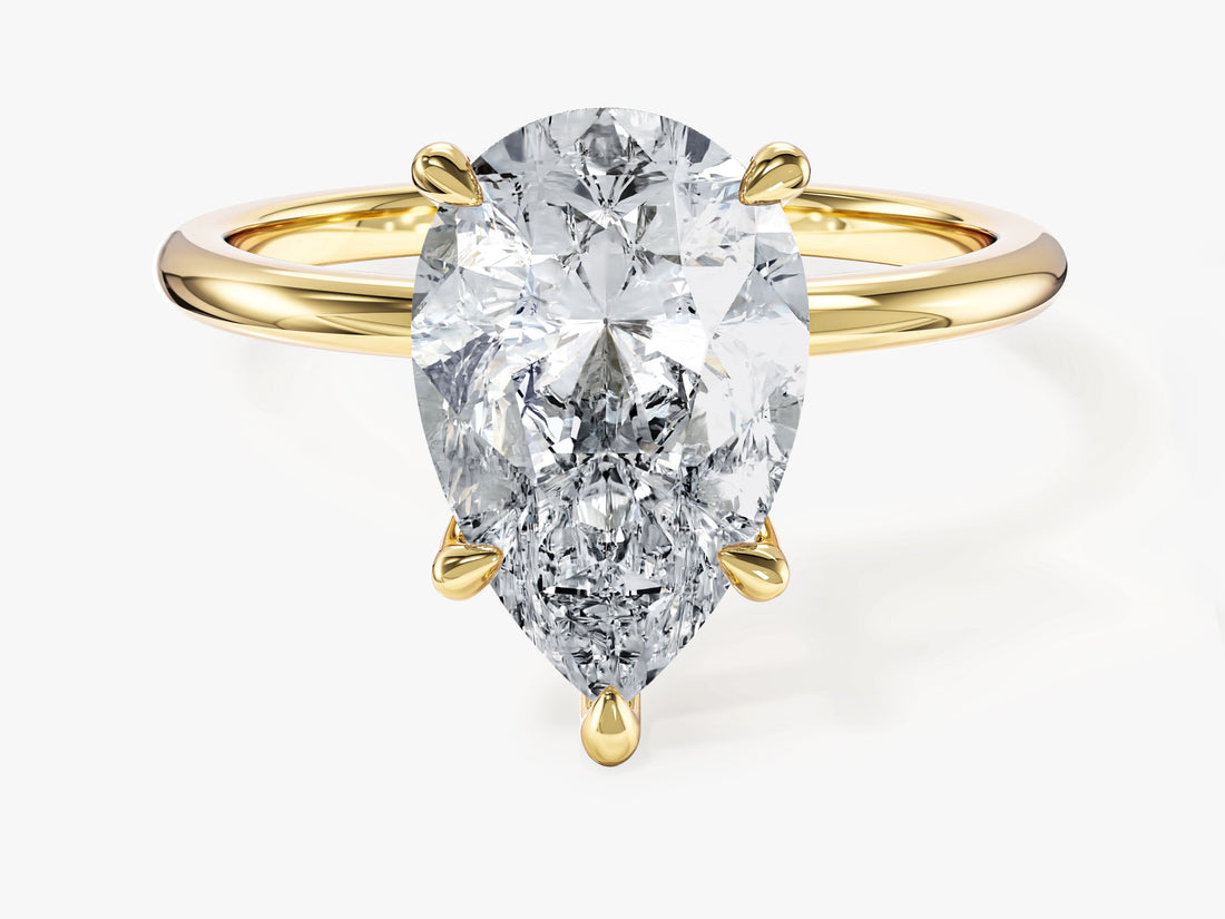 Pear cut moissanite solitaire engagement ring with plain polished band in yellow gold, front view