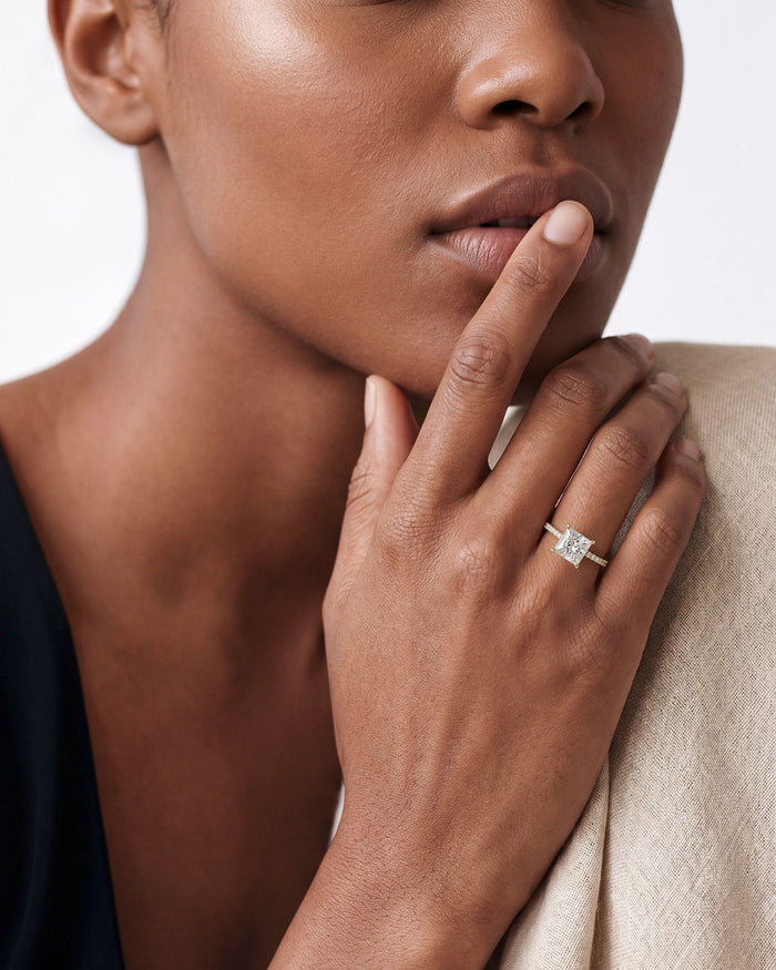 Square princess lab grown diamond engagement ring worn on the hand raised to the lips