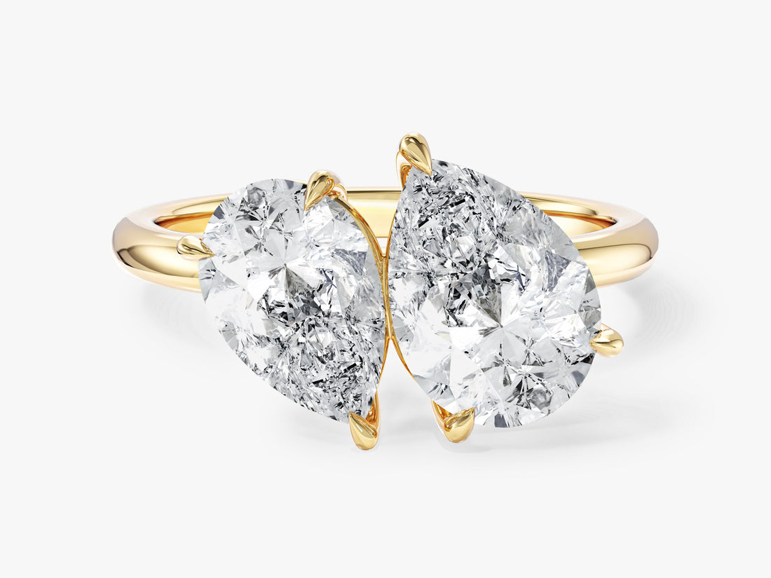 Pear cut moissanite toi et moi two stone engagement ring on a plain band in 14K yellow gold, front view