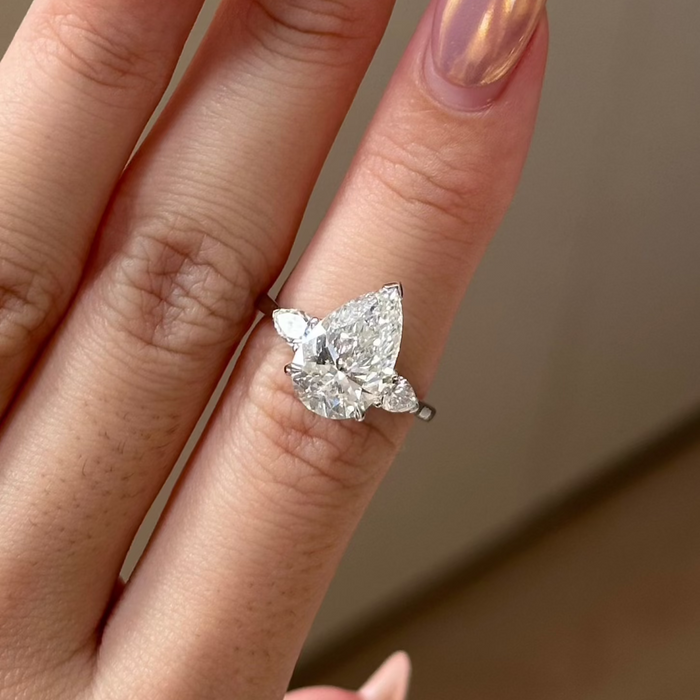 Pear cut moissanite three stone engagement ring with pear side stones in white gold
