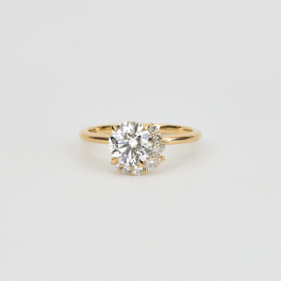 Round brilliant moissanite asymmetric crescent cluster engagement ring in yellow gold