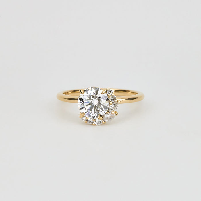 Round brilliant moissanite asymmetric crescent cluster engagement ring in yellow gold