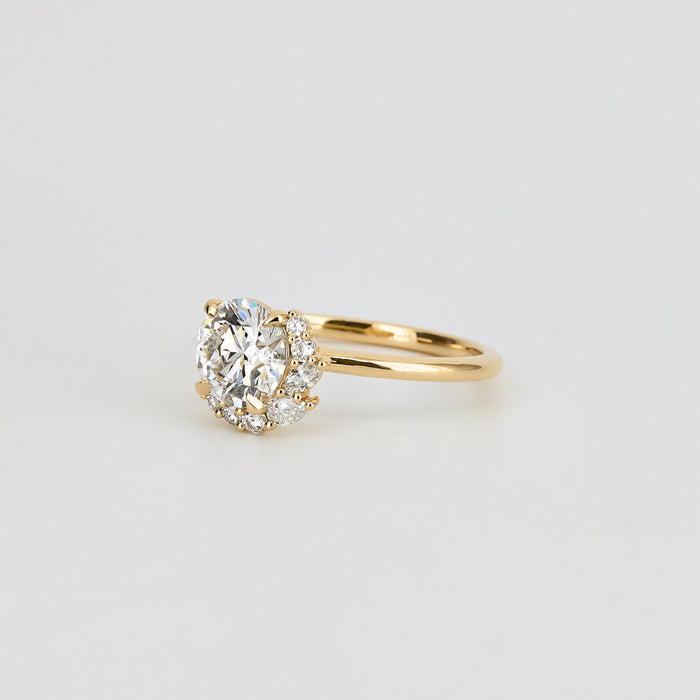 Round brilliant moissanite asymmetric crescent cluster engagement ring in yellow gold, view 2
