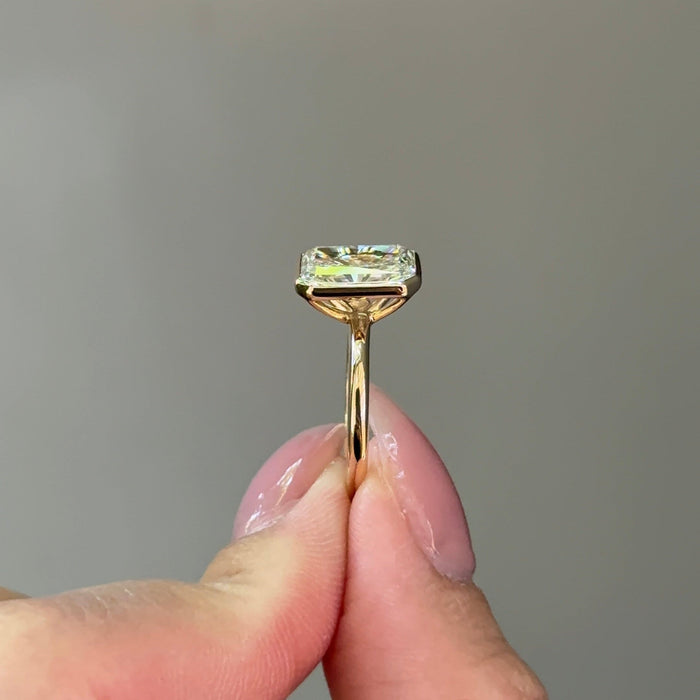 Radiant cut moissanite bezel set solitaire engagement ring in yellow gold, view 2