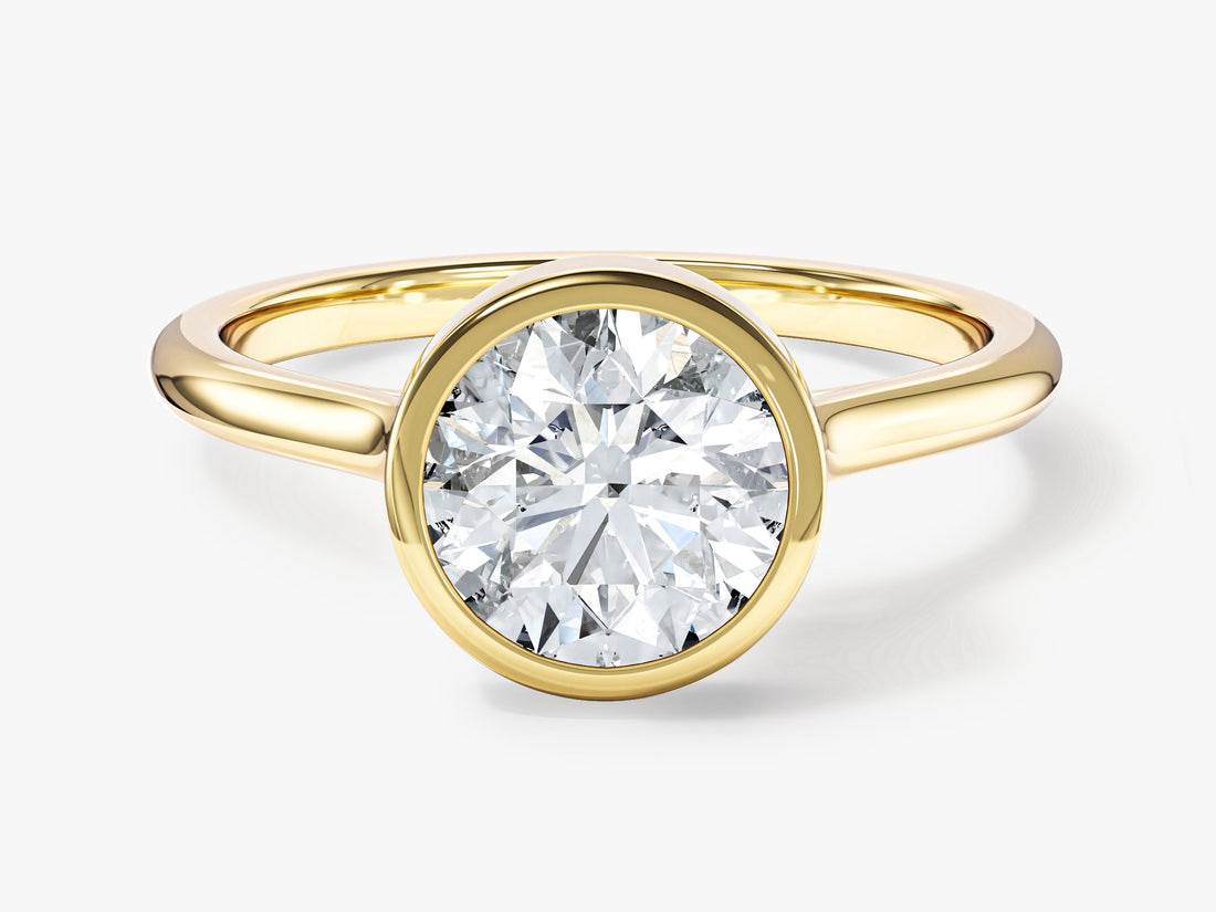Round cut moissanite bezel solitaire engagement ring with slim band in yellow gold, front view