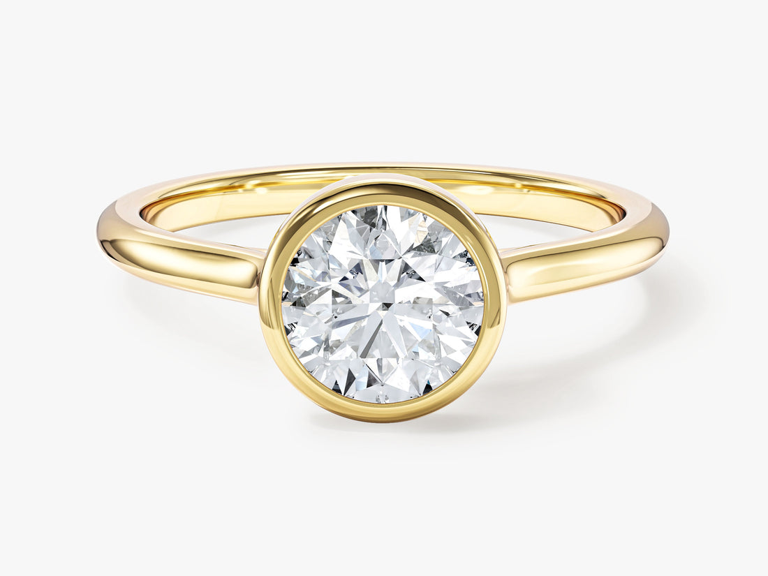 Round lab grown diamond bezel solitaire ring with slim rounded band in yellow gold, front view