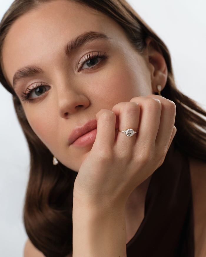 Round lab grown diamond leaf cluster ring worn on the hand under the chin