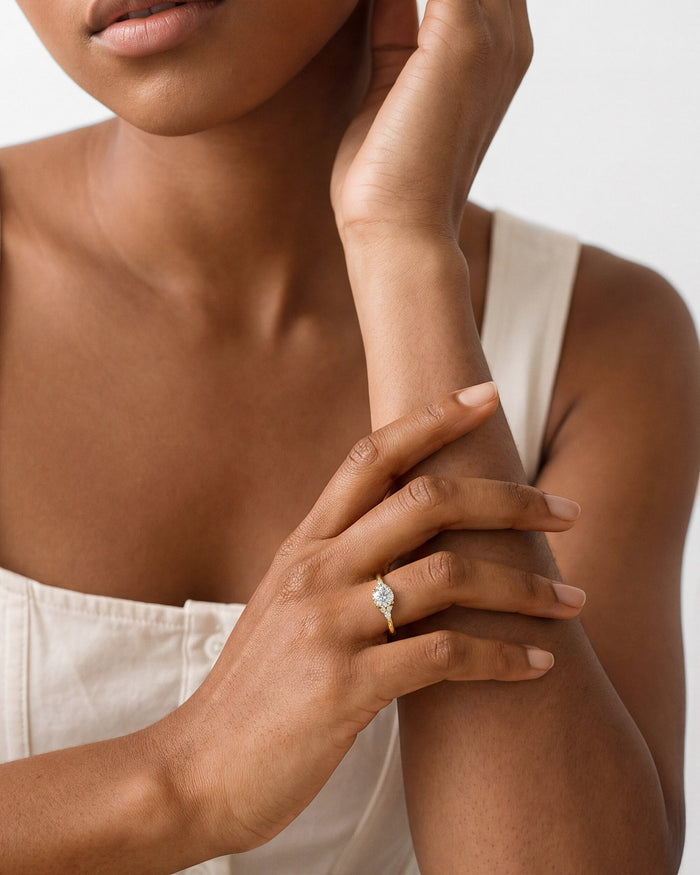 Round lab grown diamond cluster accent ring worn on the hand resting on the forearm